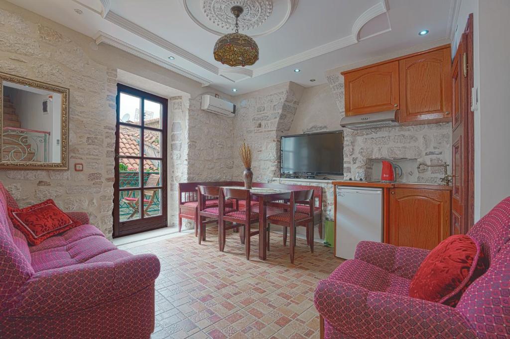 a kitchen and dining room with purple chairs and a table at Apartments Wine House Old Town in Kotor