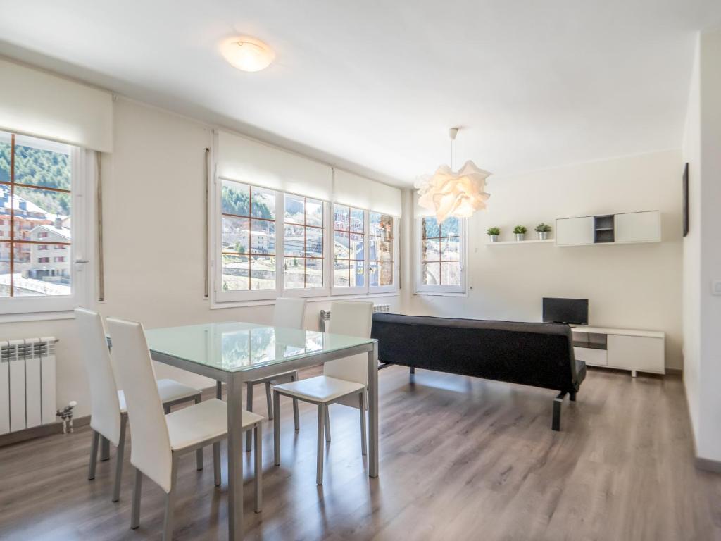 une salle à manger avec une table en verre et des chaises blanches dans l'établissement Riu D'Incles, à Incles