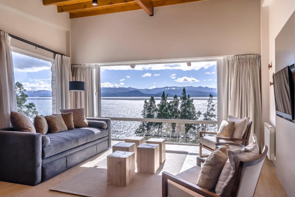 un soggiorno con divano e una grande finestra di Aguila Mora Suites & Spa a San Carlos de Bariloche