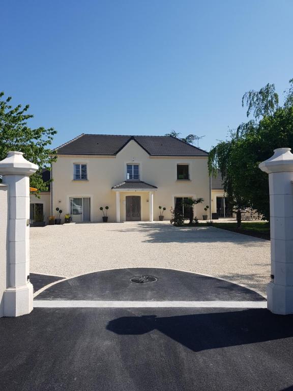 a large white house with a large driveway at La Soierie in Châteauroux