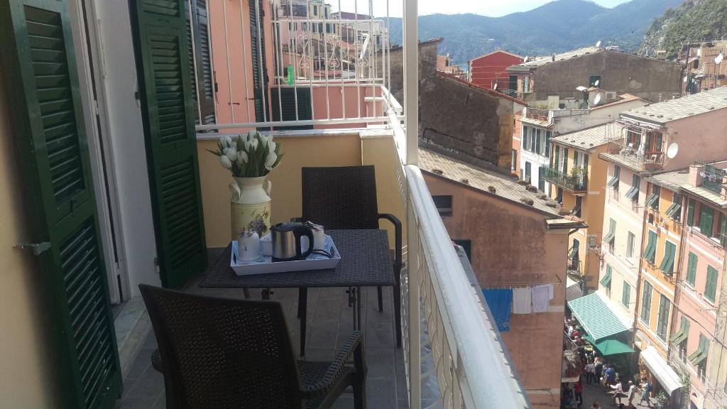 a table on a balcony with a view of a city at Guesthouse Rollando in Vernazza