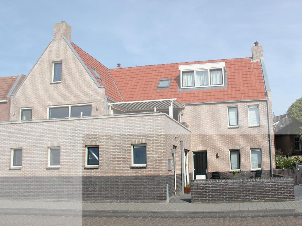 a large brick house with a red roof at TS37 in West-Terschelling