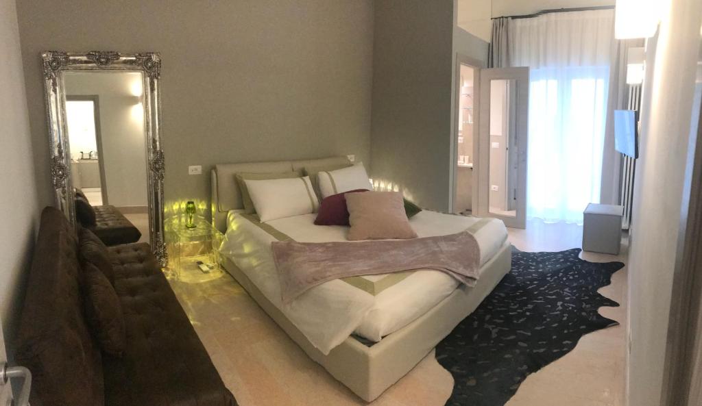 una camera con un grande letto e uno specchio di Suite La Damigella a Torri del Benaco