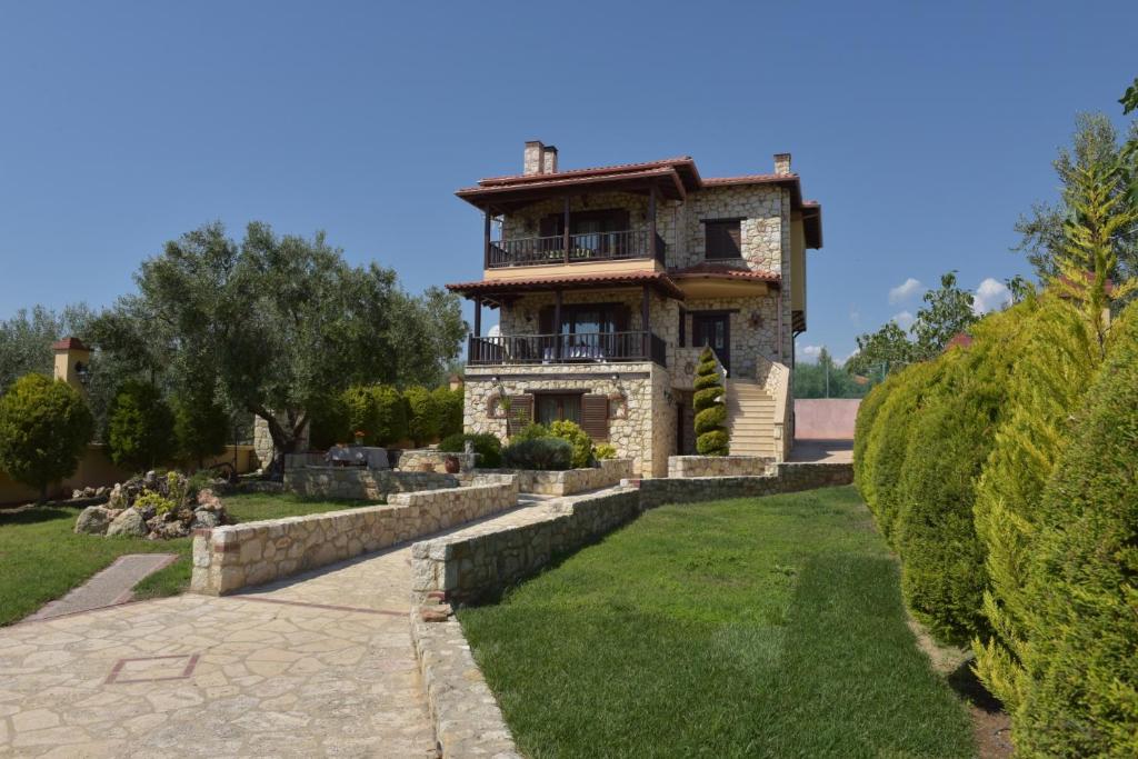 a large stone house with a large yard at Captain's Villa Appartments in Psakoudia