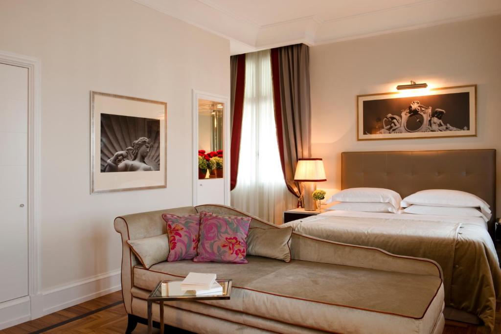 a hotel room with a bed and a couch at Savoia Excelsior Palace Trieste - Starhotels Collezione in Trieste