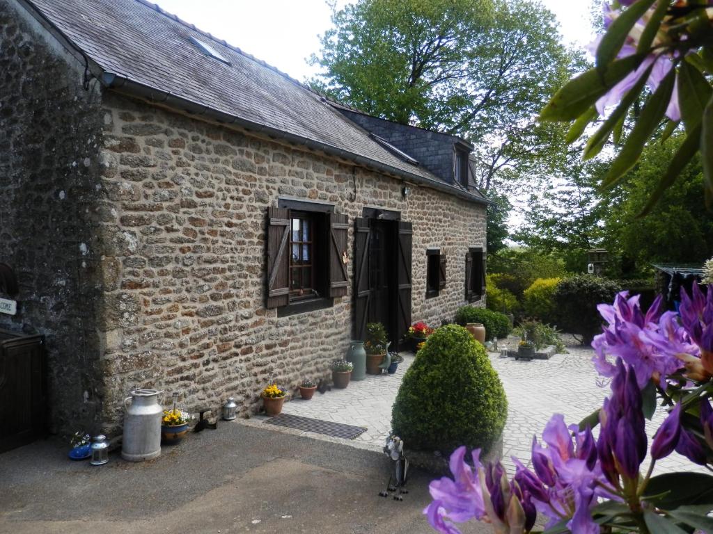 a brick house with purple flowers in front of it at La petite Cretouffiere - Naturiste Accommodation - Adult Only in Colombiers-du-Plessis