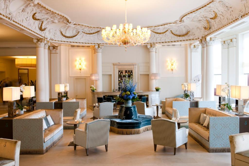 - un hall d'un hôtel avec des canapés et un lustre dans l'établissement Savoia Excelsior Palace Trieste - Starhotels Collezione, à Trieste