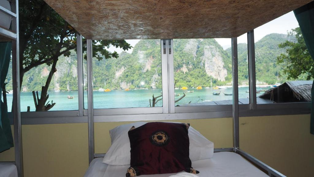 Chaokoh Phi Phi Hostel في جزيرة في في: غرفة نوم مع نافذة مطلة على الماء
