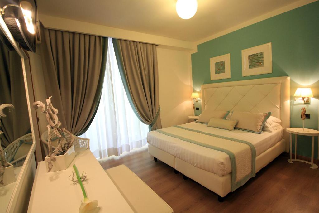 a bedroom with a bed with green walls and windows at Raffaelli Park Hotel in Forte dei Marmi