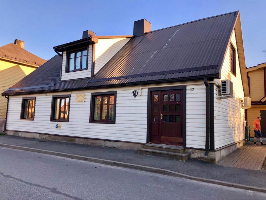 una casa blanca con techo negro en Apartments Weintrauben, en Pärnu