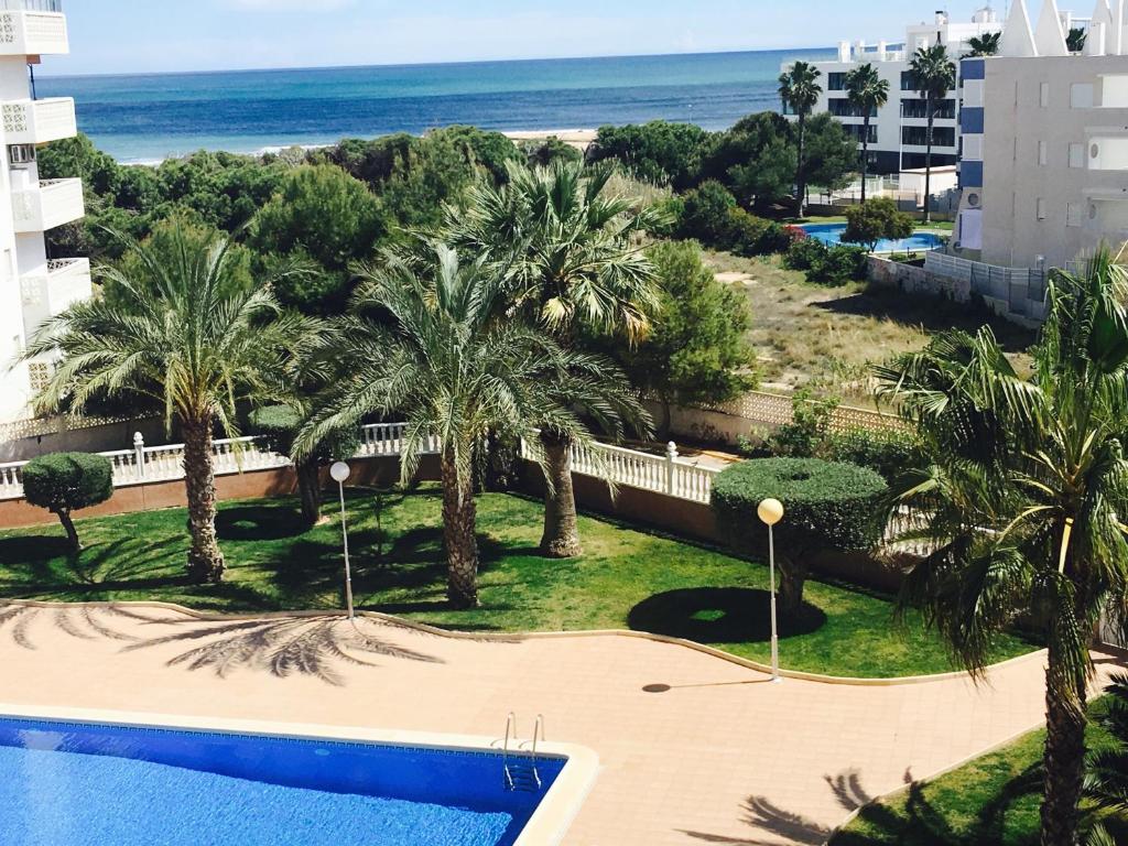 グアルダマル・デル・セグラにあるMimosa Apartmentのリゾートのバルコニーからプールとビーチの景色を望めます。