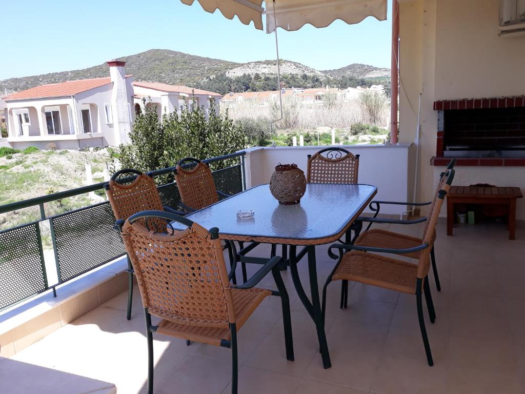 una mesa y sillas en un balcón con vistas en The Pearl en Néa Péramos