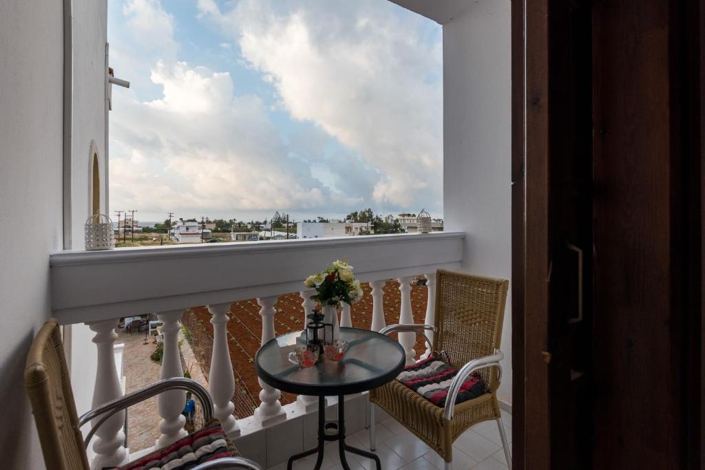 a balcony with a table and chairs and a window at Olympus Studios in Malia