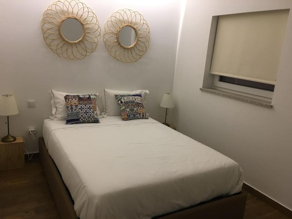 a bedroom with a bed with two mirrors on the wall at Casa do Peso 1 in Peso da Régua