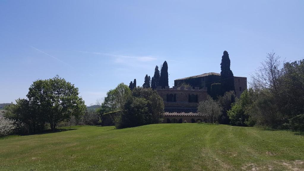 a large house on a hill with a green field at villa montalcino palazzina castelverdelli in Siena