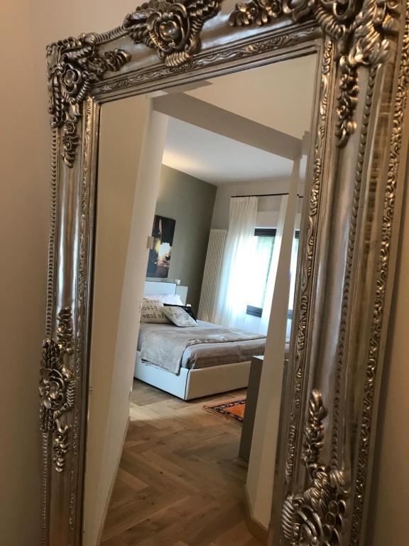 einen goldenen Spiegel in einem Schlafzimmer mit einem Bett in der Unterkunft Suite La Castellana in Torri del Benaco