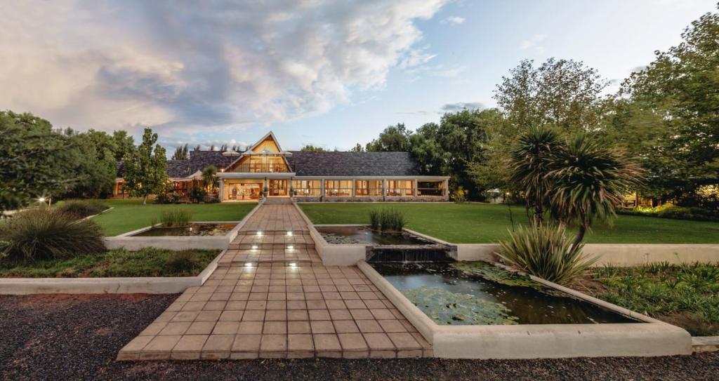 a house with a pond in front of it at Villiera Guesthouse in Douglas