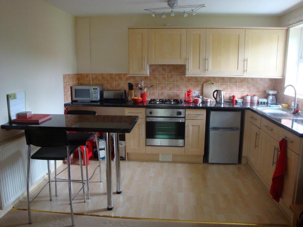a kitchen with wooden cabinets and a counter top at Foss Flat in York