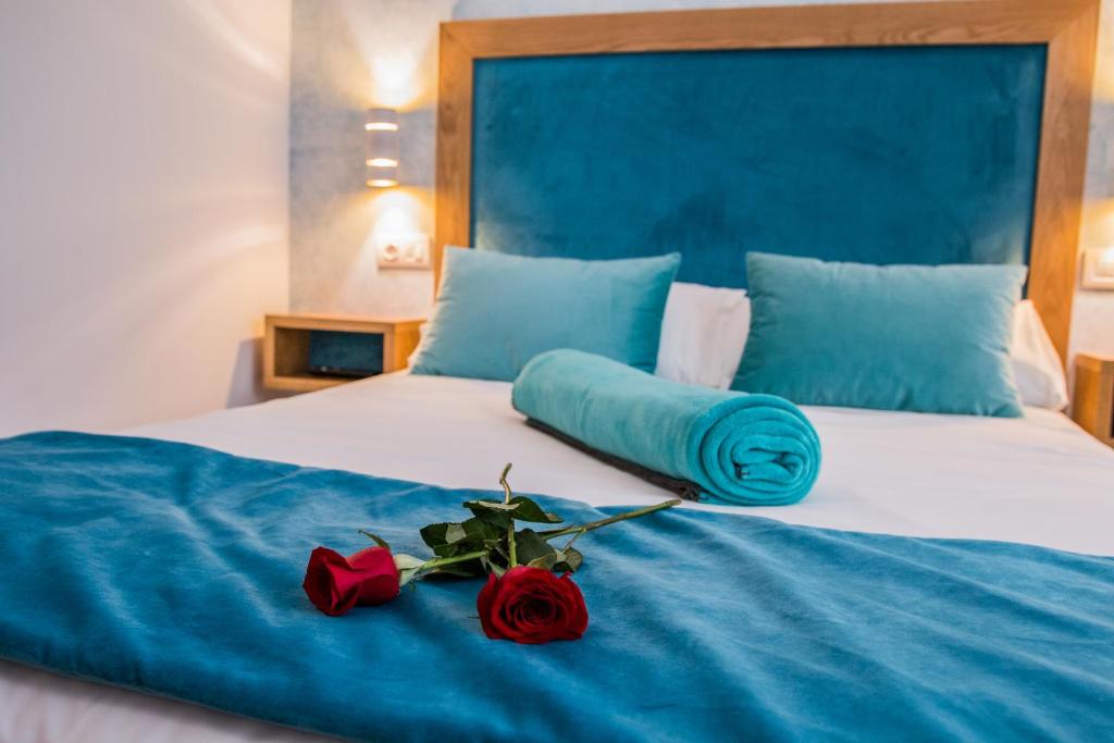 a bed with two roses on top of it at Casa da Balconada in Santiago de Compostela