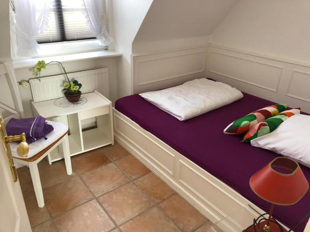 ヴェスターラントにあるKastanienhüs Apartmentのベッドとテーブル付きの小さな部屋