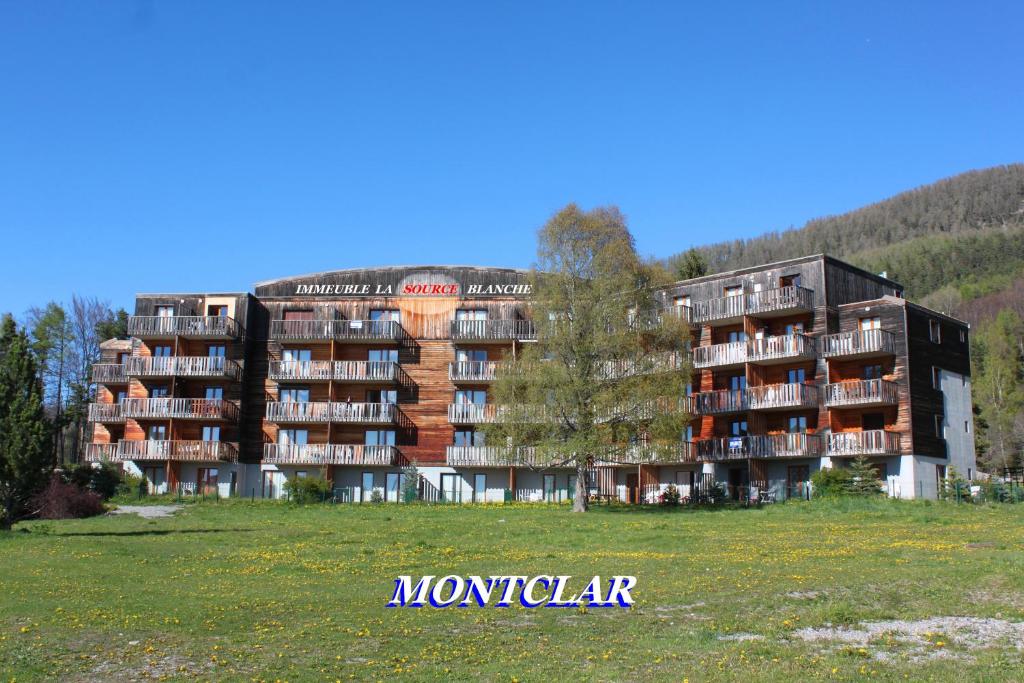 a large apartment building in the middle of a field at LA Source Blanche in Saint-Jean