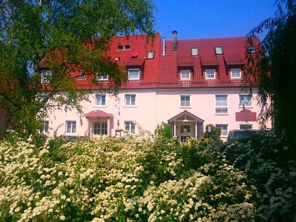 ein großes weißes Gebäude mit rotem Dach in der Unterkunft Engelhof in Weilheim an der Teck