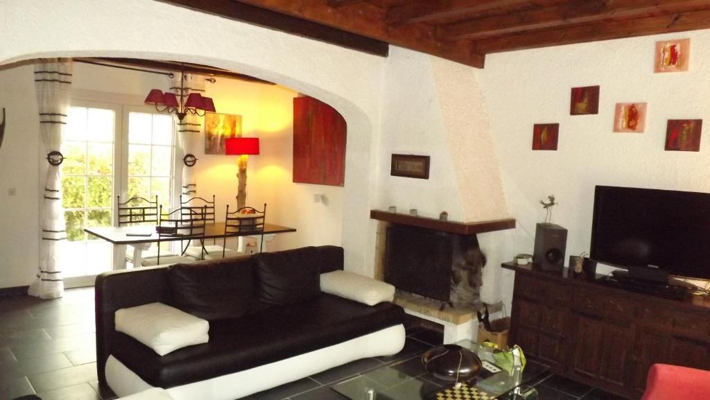 a living room with a black couch and a fireplace at Casa June in Torroella de Montgrí