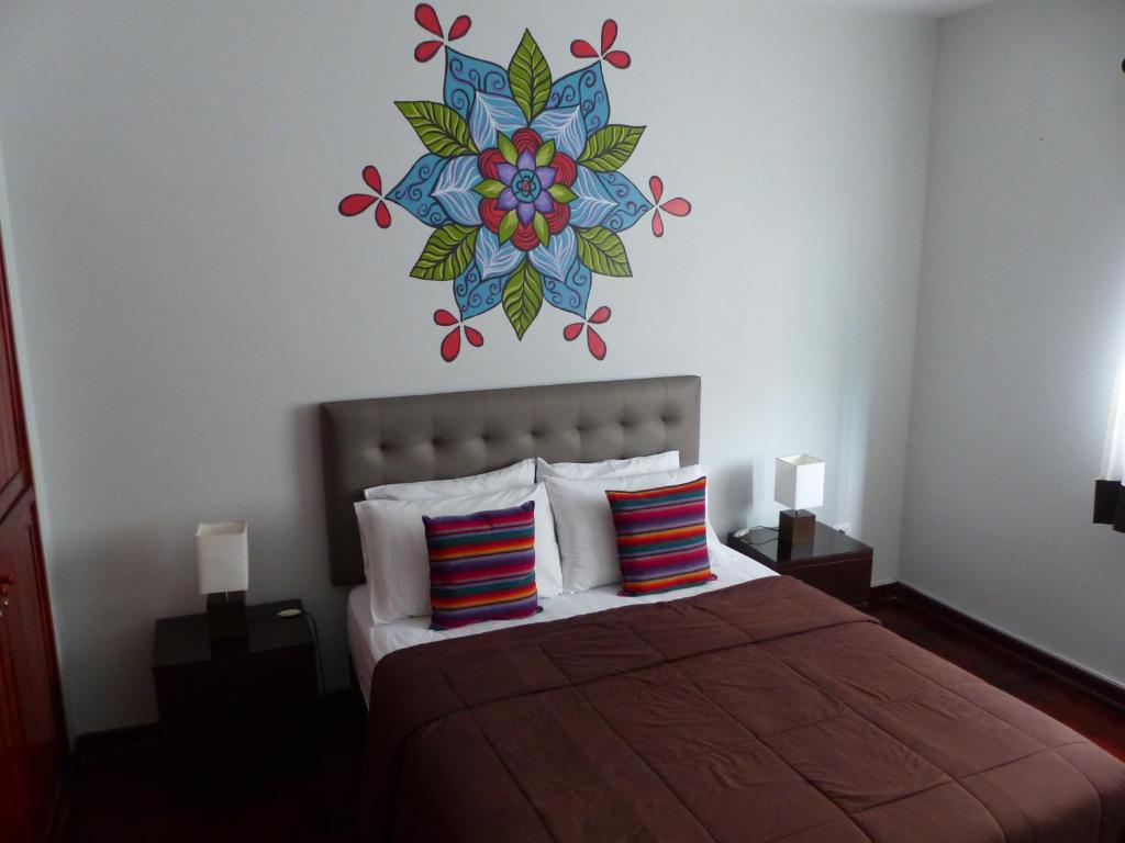 1 dormitorio con 1 cama con mandala en la pared en The Lighthouse Bed and Breakfast, en Lima