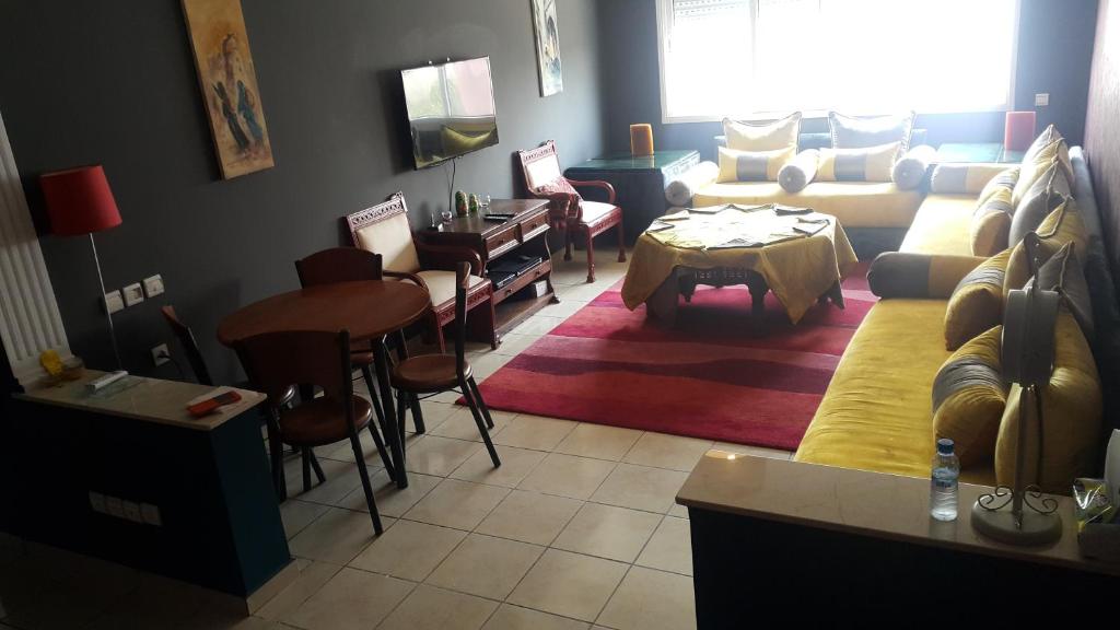 - un salon avec un canapé et une table dans l'établissement Sunny appart Residence Nour Californie, à Casablanca