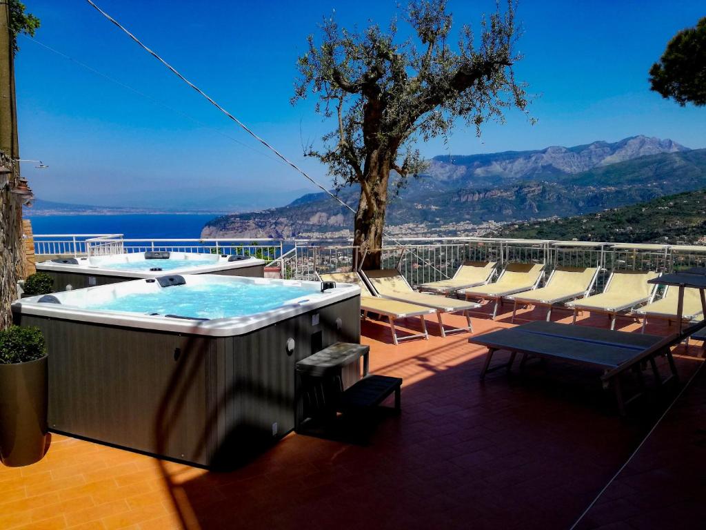 bañera de hidromasaje en un patio con sillas y mesa en Hotel Villa Fiorita en Sorrento