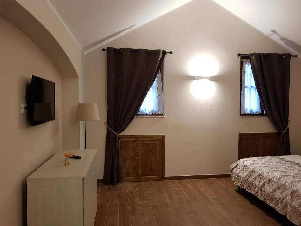um quarto com uma cama e uma televisão na parede em La casa del gnocco em Masone