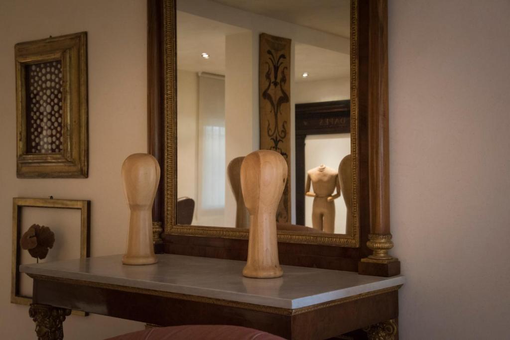 lustro na półce z drewnianym przedmiotem przed nim w obiekcie B&B Villa dei Calchi - Suite Room di Charme w mieście San Felice sul Panaro