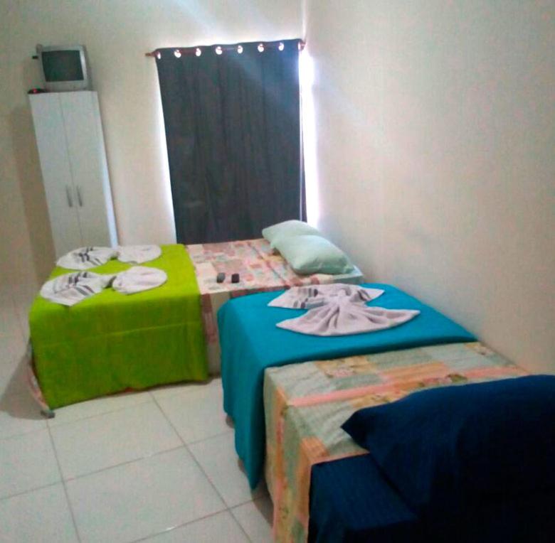 two beds sitting next to each other in a room at Pousada Oluap in Mairiporã