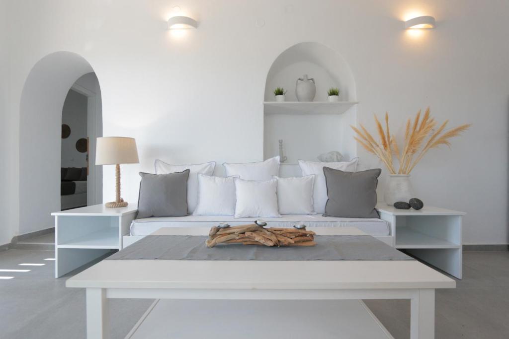 a living room with a white couch and a table at Bonatsa House in Agios Georgios