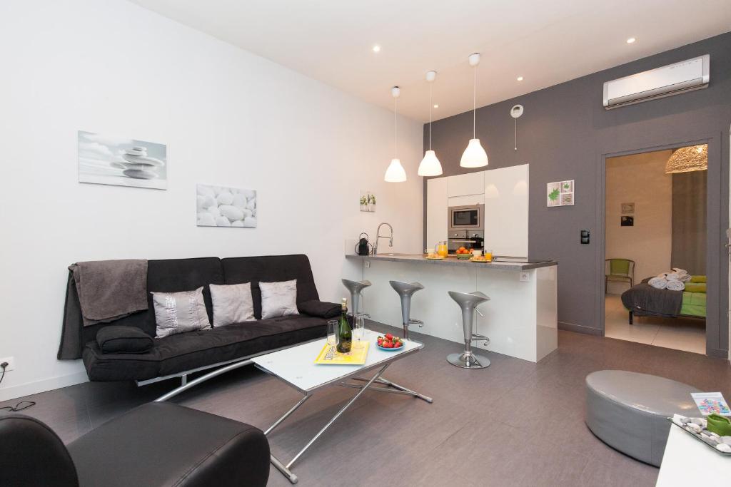un salon avec un canapé et une table dans l'établissement ZEN 2 pièces 3 étoiles, plein centre cannes, à 5mn des plages et du palais, à Cannes