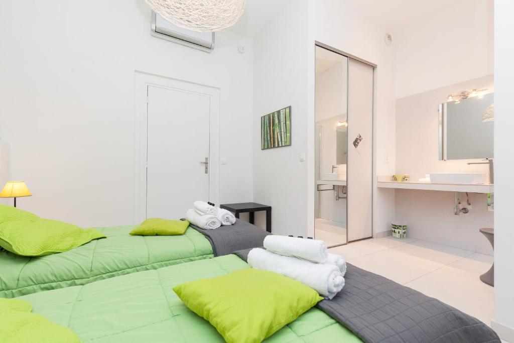 Cette chambre comprend 2 lits verts et une salle de bains. dans l&#39;établissement ZEN 2 pièces 3 étoiles, plein centre cannes, à 5mn des plages et du palais, à Cannes