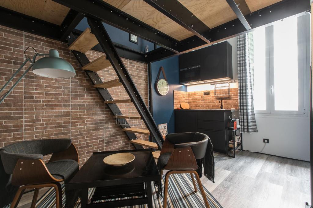ein Loft mit einer Treppe und einem Tisch und Stühlen in der Unterkunft Mezzanine Studio near Monaco in Roquebrune-Cap-Martin
