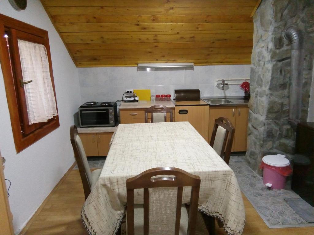 a kitchen with a table with chairs and a stove at Apartman Mika in Soko Banja