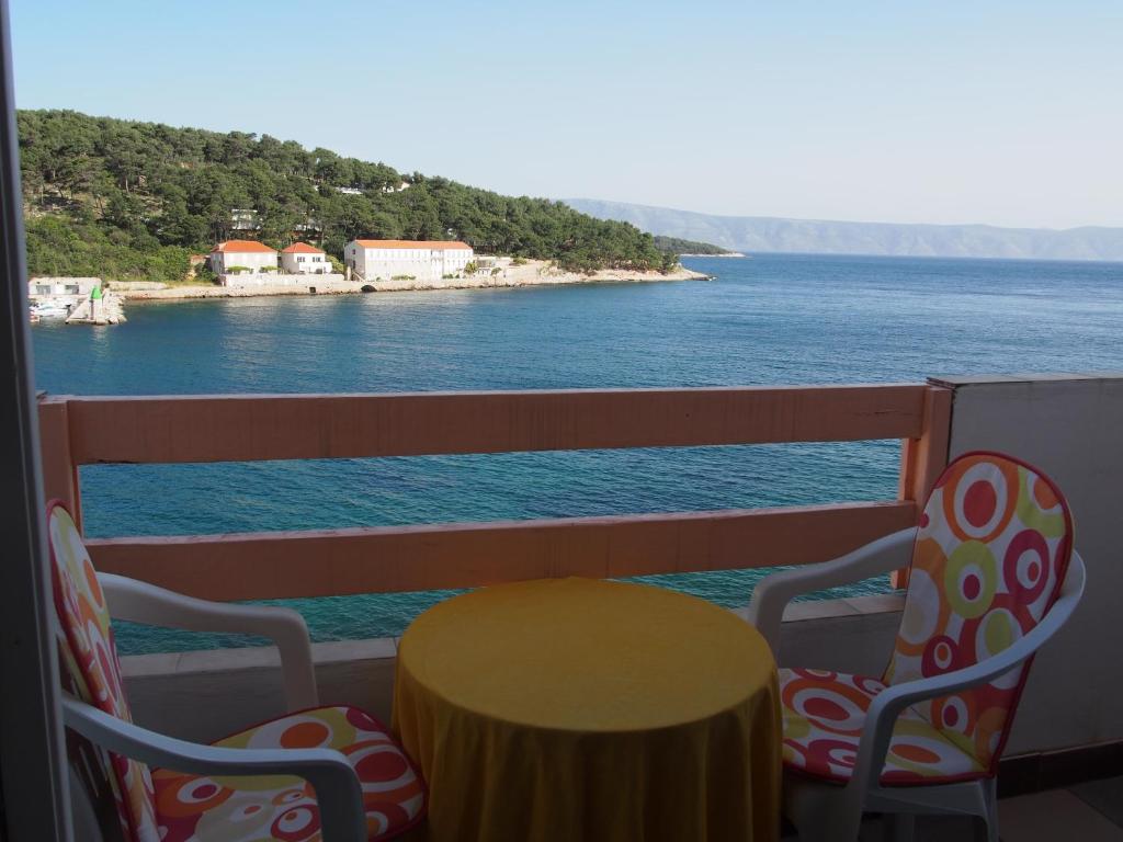 a table and chairs on a balcony overlooking the water at Beachfront Apartment Jelsa in Jelsa