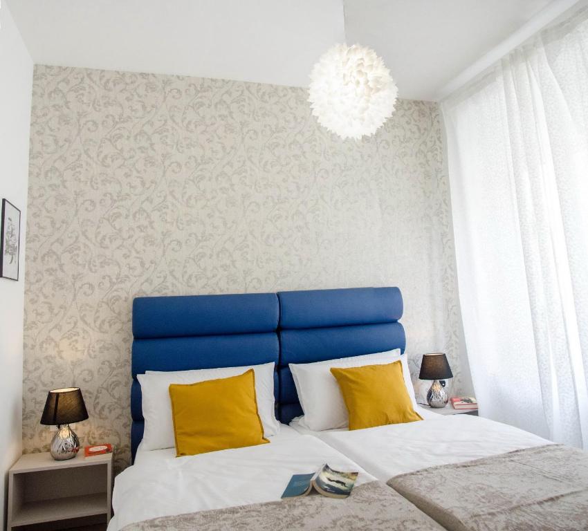 a bedroom with a blue and white bed with yellow pillows at San Martino Rooms in Pula