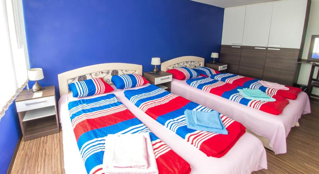 two beds with colorful blankets and pillows in a room at Guesthouse Stari Grad in Mostar