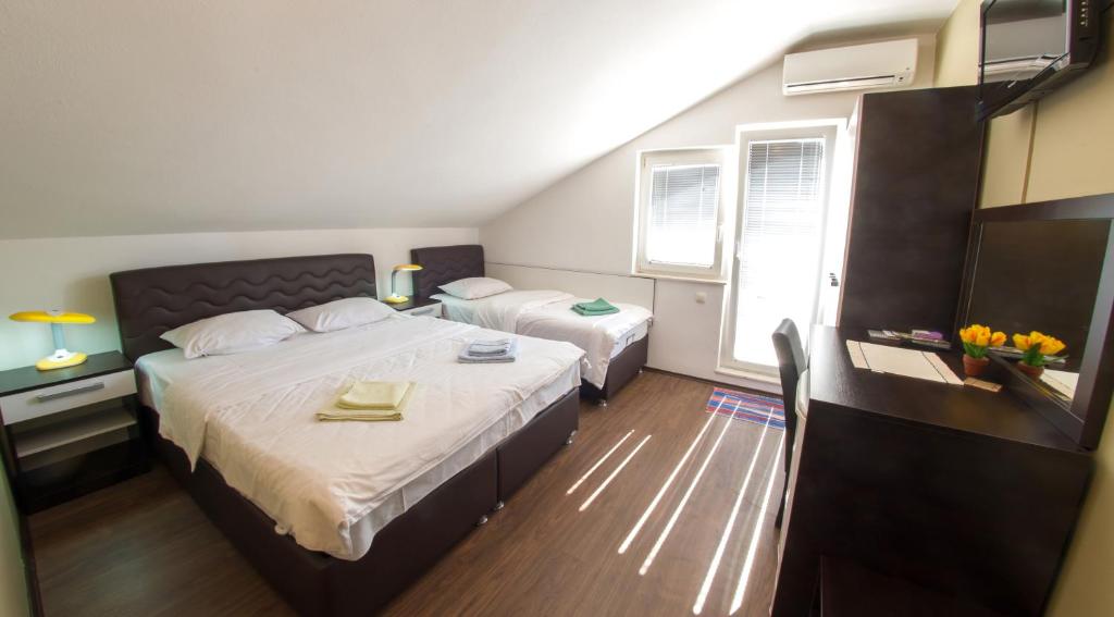 a hotel room with two beds and a television at Guesthouse Stari Grad in Mostar