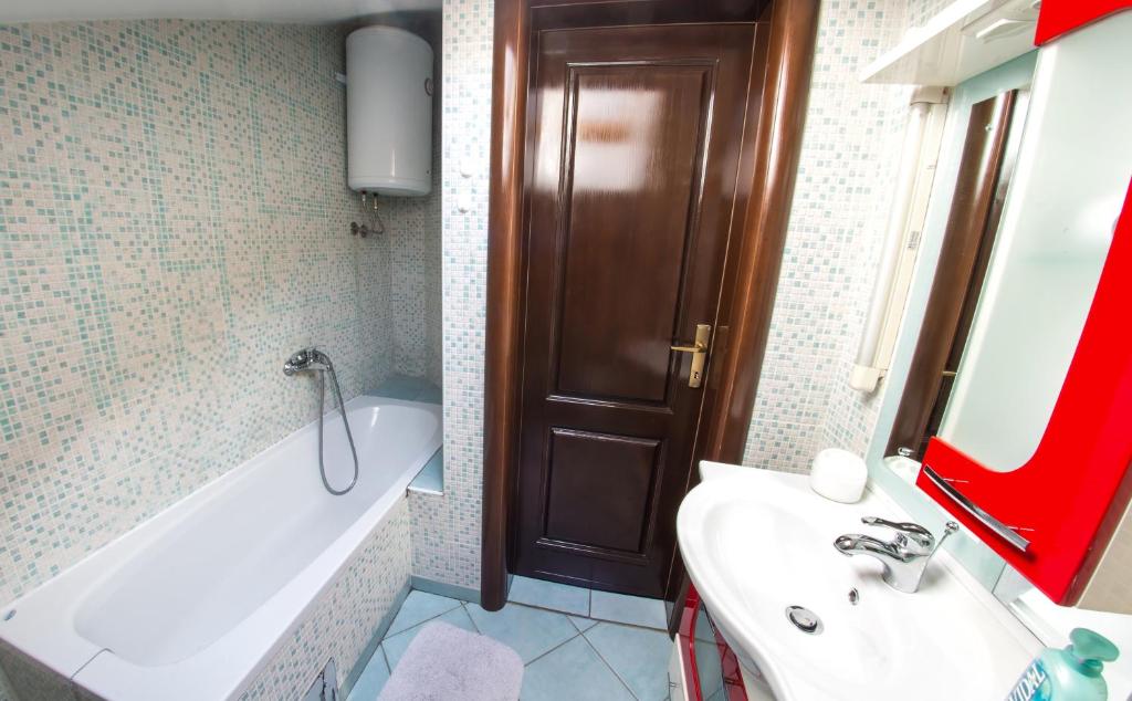 a bathroom with a white tub and a sink and a bath tub at Guesthouse Stari Grad in Mostar