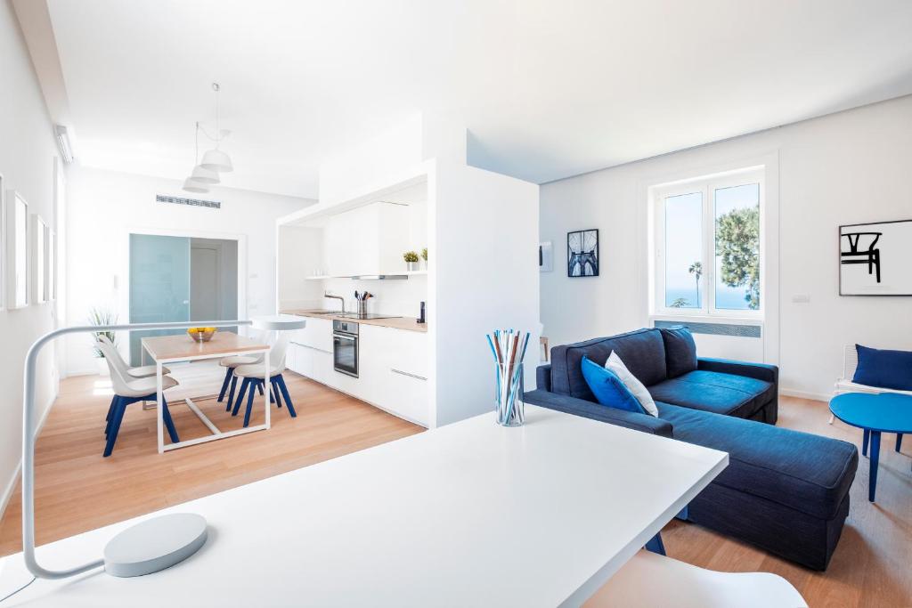 un soggiorno con divano blu e tavolo di AE Home|Studio a Sorrento