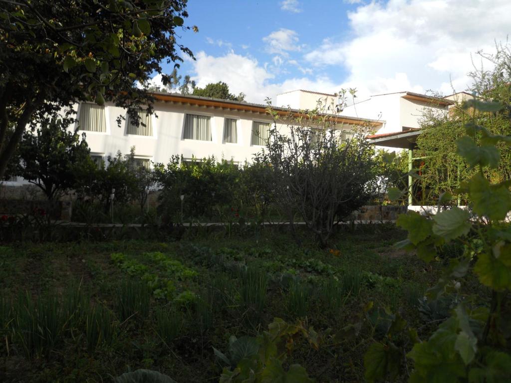 ein weißes Haus mit einem Garten davor in der Unterkunft Hotel El Abuelo in Carhuaz