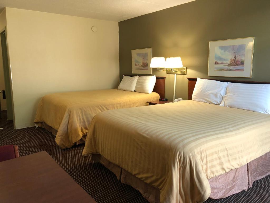 une chambre d'hôtel avec 2 lits et 2 lampes dans l'établissement Norwood Inn & Suites Worthington, à Worthington