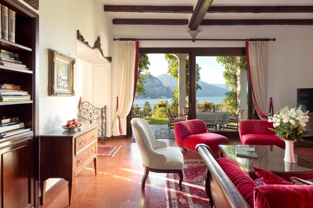 a living room with red furniture and a large window at Villa Poletti in Bellagio