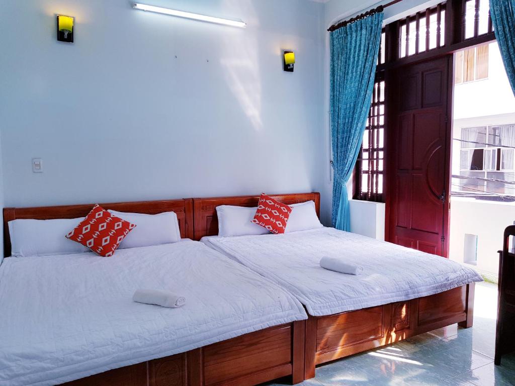 ein Schlafzimmer mit einem großen Bett mit roten und weißen Kissen in der Unterkunft Minh Hien Hotel in Vũng Tàu