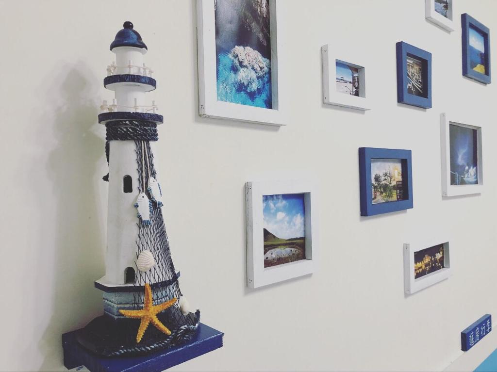 a statue of a lighthouse on a wall with pictures at FUNSUMMER in Green Island