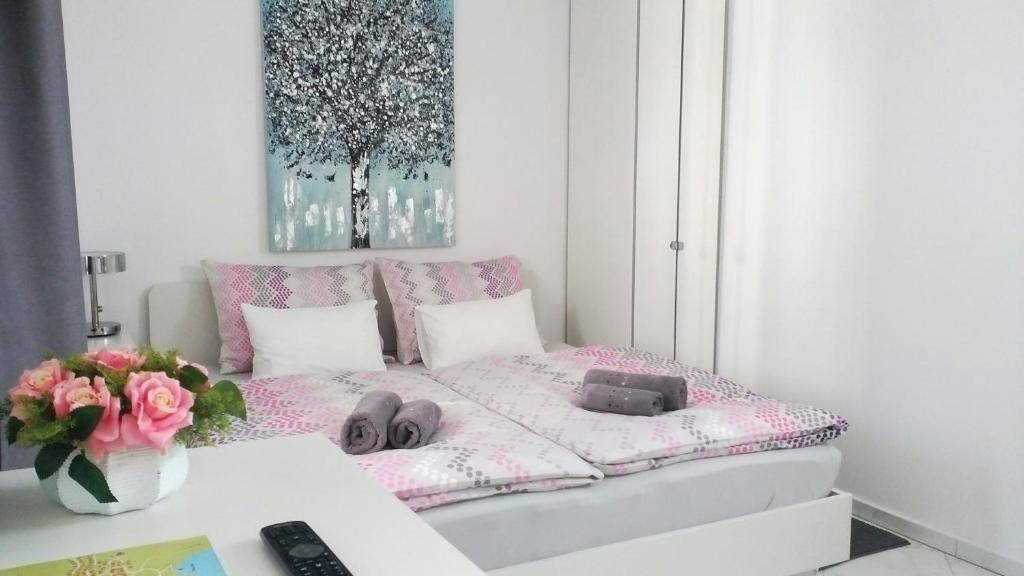 a room with a bed with a table and a vase of flowers at Apartman Marja - Studio in Njivice